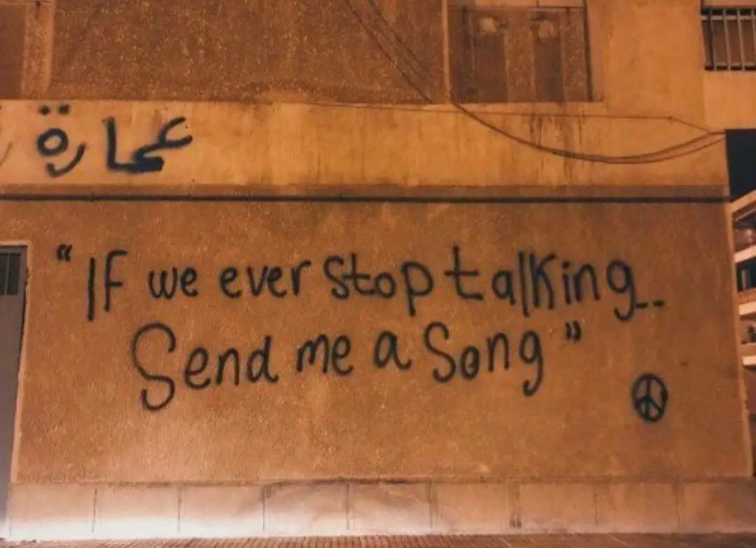 A wall graffiti with the text ‘if we ever stop talking, send me a song’