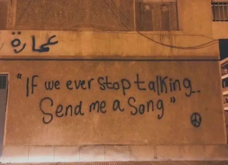A wall graffiti with the text &lsquo;if we ever stop talking, send me a song&rsquo;